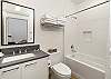 Bathroom #1 is an en suite with tiled shower and tub