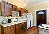 Kitchen area with Keurig coffee maker, microwave, refrigerator, and basic cookware, dishes and utensils.