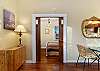 Pocket doors lead from living room into bedroom with queen size bed.