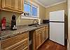 Kitchenette with Keurig coffee maker and refrigerator.