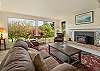 Open living room with large windows and cozy fireplace (firewood not provided)
