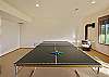 Ping pong table on lower floor with wood stove