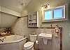 The bathroom is nicely tiled with a large jetted-soaking tub. The tub has an extending sprayer in lieu of a shower head.