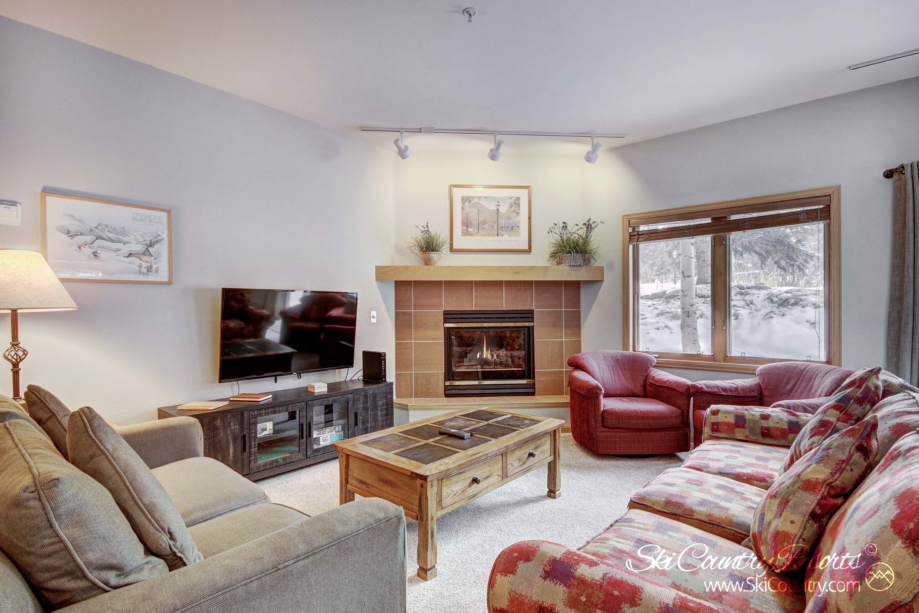 The spacious living room, boasting ample seating options, a cozy gas fireplace and flatscreen TV is guaranteed to delight with its breathtaking mountain views and abundance of natural light. An ideal sanctuary to unwind after a day of adventure.