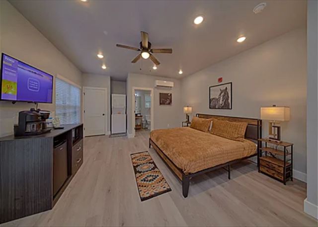 One room studio condo with king bed, tv, microwave, refrigerator, and coffee maker.