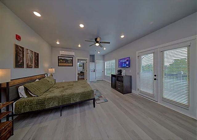 Spacious one room condo has a king bed with tv, microwave, refrigerator, and coffee maker.