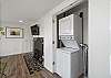 Stackable washer/dryer off of living area with woodstove and smart TV