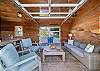 Outdoor living space with covered lounging furniture, streaming TV, dining area, open to back yard with BBQ. With uncovered sun deck for lounging