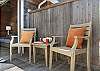 Outdoor living space with covered lounging furniture, streaming TV, dining area, open to back yard with BBQ. With uncovered sun deck for lounging