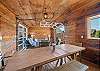 Outdoor living space with covered lounging furniture, streaming TV, dining area, open to back yard with BBQ. With uncovered sun deck for lounging