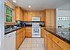 Fully equipped kitchen with breakfast bar, open to dining and living area with gas fireplace