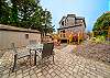 Back Courtyard with outdoor dining table and chairs, lounge chairs, and fenced yard. 