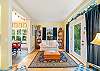 Sitting room with books and access to kitchen and outdoor space with hot tub and bbq