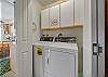 Downstairs laundry closet with washer and dryer.