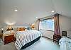 Upstairs master bedroom with King bed and Twin bed. Attached master bath with shower, access to third floor oceanview deck with fire table and deck chairs. 