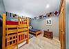 Bunk room with bunk bed with twin trundle and twin bed.