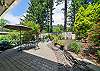 Back yard area with cocktail table, outdoor dining table with umbrella, Gas BBQ, and outdoor fire pit. 