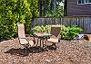 Back yard area with cocktail table, outdoor dining table with umbrella, Gas BBQ, and outdoor fire pit. 