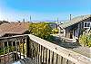 Deck off the living area with ocean views, outdoor dining table, and adirondack chairs. Wraps around to a wind blocked area as well. 