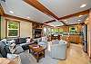 Open living space with wood fireplace, dining nook with bench seating, fully equipped kitchen.