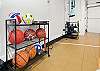 Sport court, free weights, and exercise mats in garage with window wall that opens up to outside. 