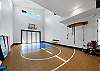 Indoor sports court with basketball hoop, pickleball, exercise corner and exercise mats