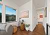 Living room with streaming TV, ocean view, and comfortable seating. Hallway to the bedrooms and baths. 