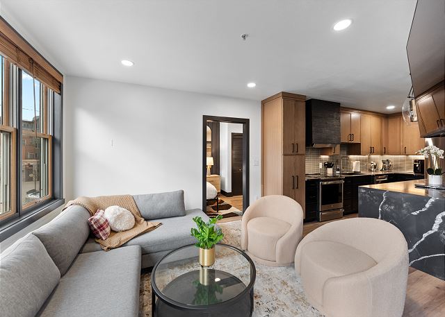 Living area featuring a mounted TV, electric fireplace, and balcony access. 
