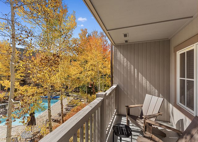 Private balcony with outdoor seating and pool views. 