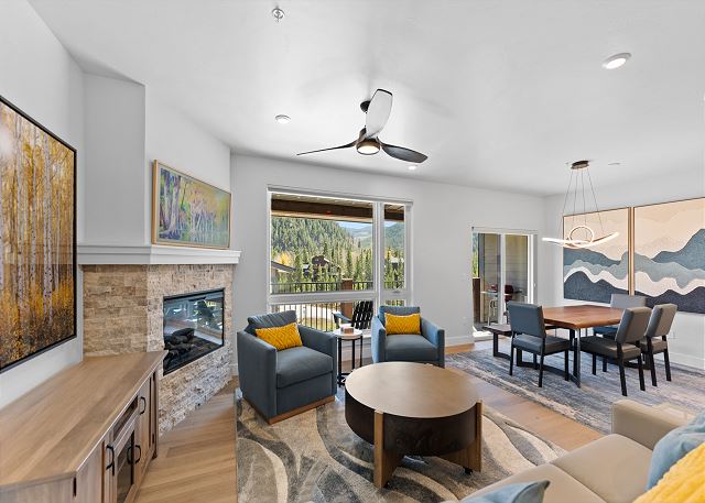 Open-concept living area with ample seating, cozy fireplace, TV, and queen sleeper sofa. 