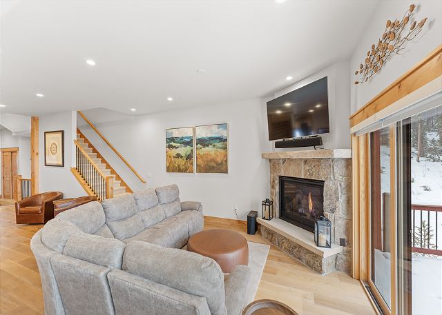 The living area features a mounted TV over a cozy fireplace.