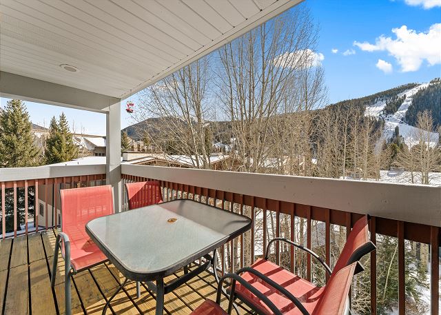 Private balcony with outdoor seating and ski-slope views. 
