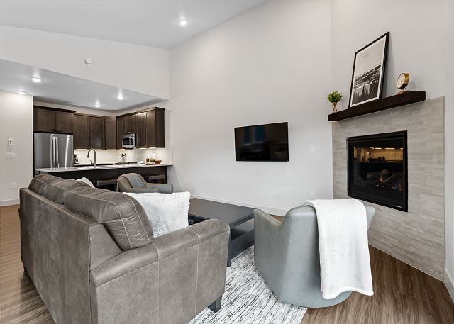 Living area with a gas fireplace, mounted TV, and queen sleeper sofa. 