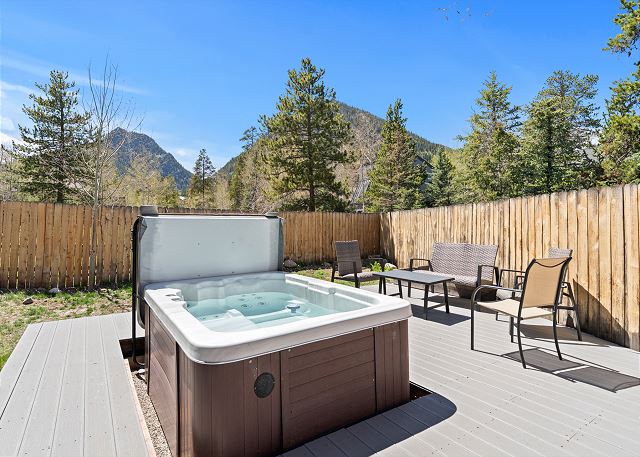 Private patio with a hot tub and outdoor furniture. 