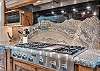 Stunning gas stove with beautiful custom granite backsplash
