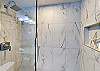 Freshen up for your next adventure in this large marble tiled walk-in shower