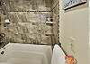 Freshen up for your next adventure in this large tiled tub and shower.