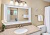 Guest bathroom equipped with stone vanities, plush towels, and bright vanity lighting.