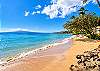 The outdoor beach area faces the turquoise ocean and neighboring island, as shown from this scenic angle along the coastline.