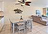The dining table seats six, creating a convenient spot for chatting while meals are prepared.
