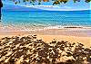 Soft morning light over the crystal-clear ocean and sandy shore, photographed from the shared grounds at Kanai A Nalu.