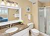 Guest bathroom equipped with stone vanities, plush towels, and bright vanity lighting.