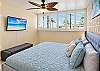Ocean views from the primary bedroom, with a king bed and bedside tables.