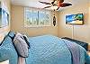 Garden views and soft island breezes fill the second bedroom through crisp plantation shutters beside a King bed.