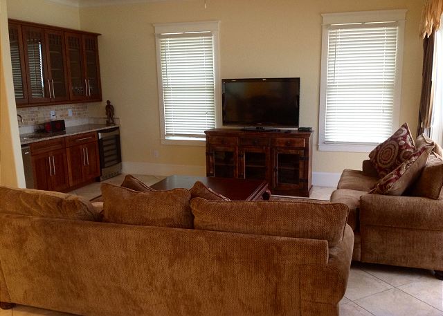 The living room has very comfortable furniture and also features a large flat screen TV, ice maker and wet bar.