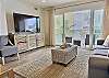 The bright, airy living room opens to a private balcony with a natural gas BBQ. The balcony seating offers the perfect spot to relax and enjoy the coastal breeze.