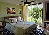 Spacious bedroom with natural light and drapes for privacy.