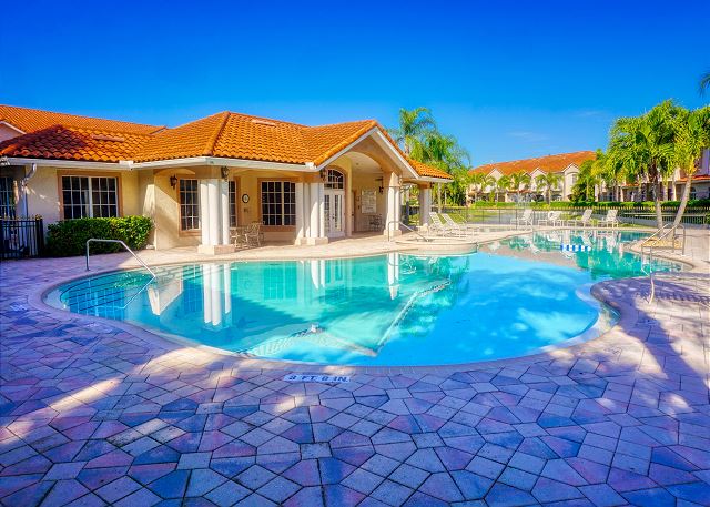 Looking towards the Club House from the South end of the pool. There is table seating under the covered area at both ends along with lounge chairs around the pool deck.