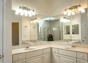 The walls above the vanities are mirrored with separate lighting above each area.