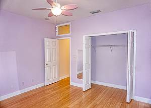 First guest bedroom view from the far corner, a spacious closet and the entry to the left.